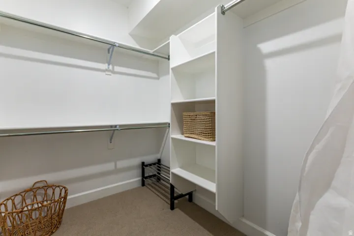 Walk in closet featuring light carpet