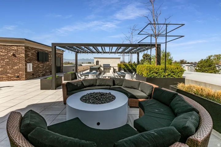 View of patio featuring an outdoor fire pit, a pergola, and an outdoor kitchen and area to lounge