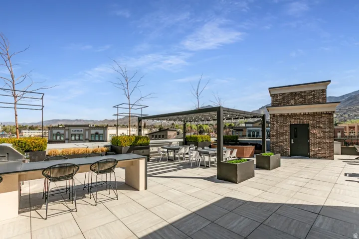 View of patio with a mountain view, exterior kitchen, and an outdoor bar and dining area