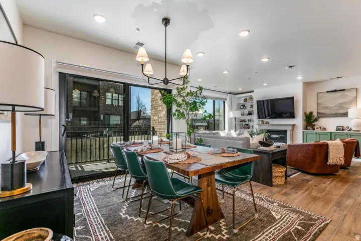 Dining room with a glass covered fireplace, dark wood-style flooring, and suspended lighting