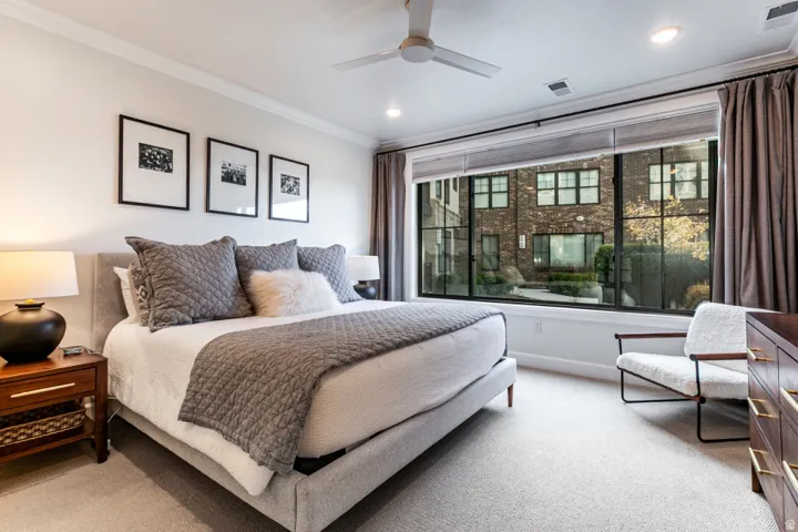 Bedroom featuring light colored carpet, crown molding, and ceiling fan