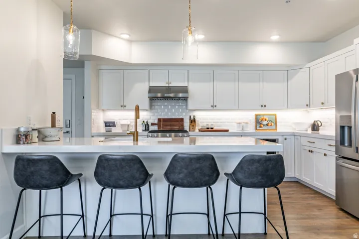 Kitchen featuring a peninsula, a kitchen breakfast bar, and white cabinets