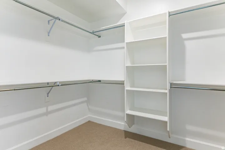 Walk in closet with light carpet