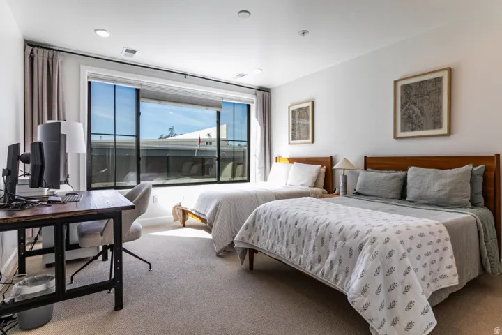 Bedroom with carpet flooring and an office area