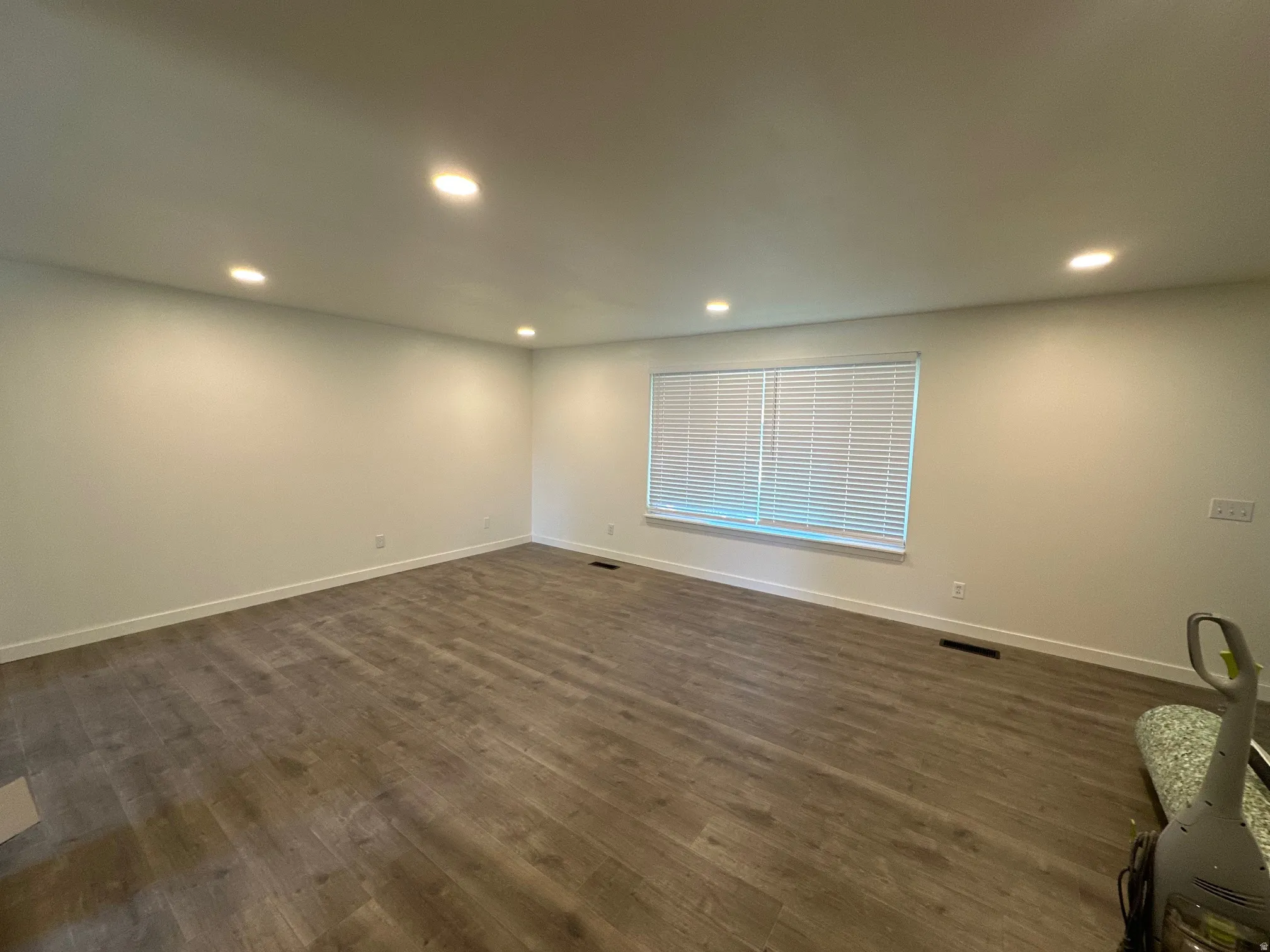 Empty room with recessed lighting and dark wood-type flooring