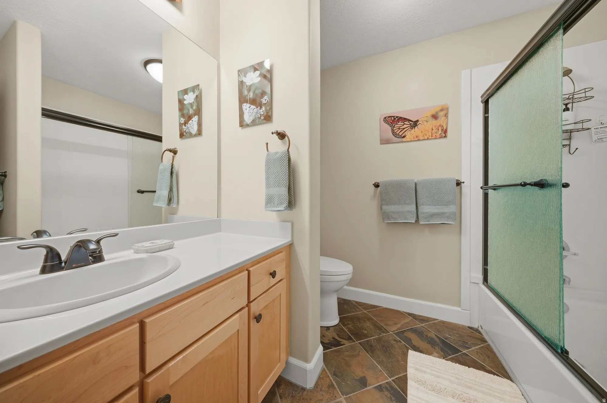 Full bathroom featuring vanity and shower / bath combination with glass door