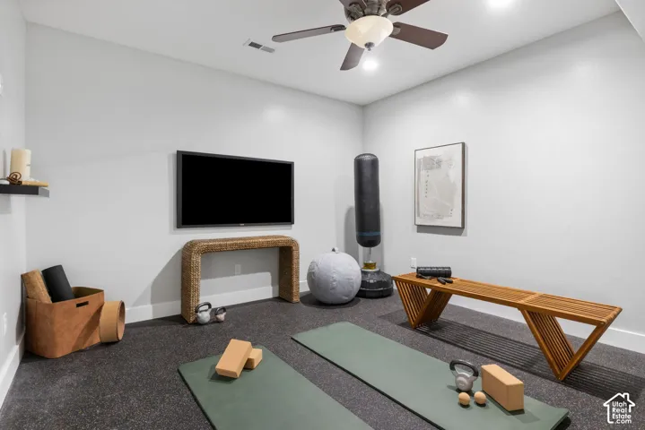 Exercise area with baseboards and a ceiling fan