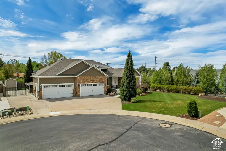 Craftsman inspired home featuring a garage, driveway, a gate, a front yard, and a shingled roof