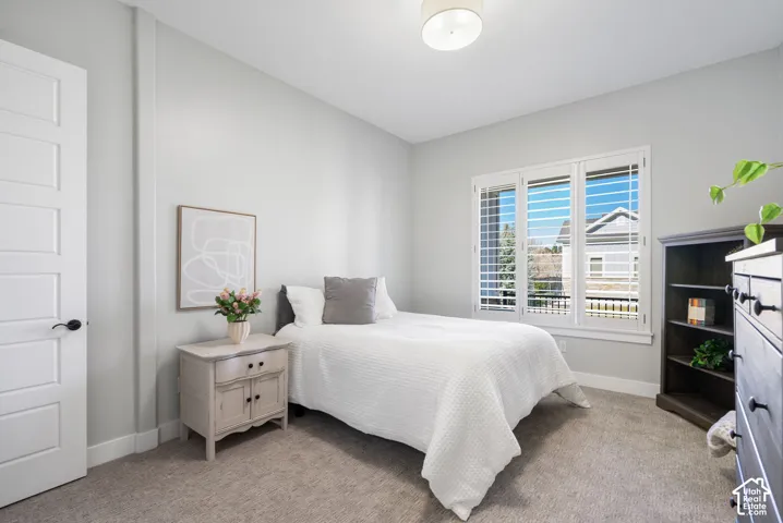 Bedroom featuring light carpet