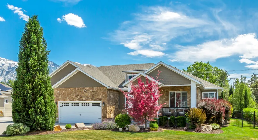 Craftsman inspired home with stone siding, driveway, a garage, a mountain view, and a porch