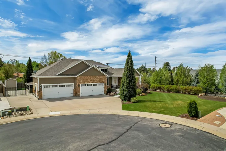 Craftsman inspired home featuring a garage, driveway, a gate, a front yard, and a shingled roof