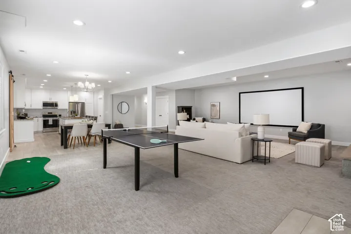 Playroom featuring suspended lighting and light colored carpet