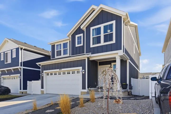 Two-story exterior with dark blue vertical siding and white trim