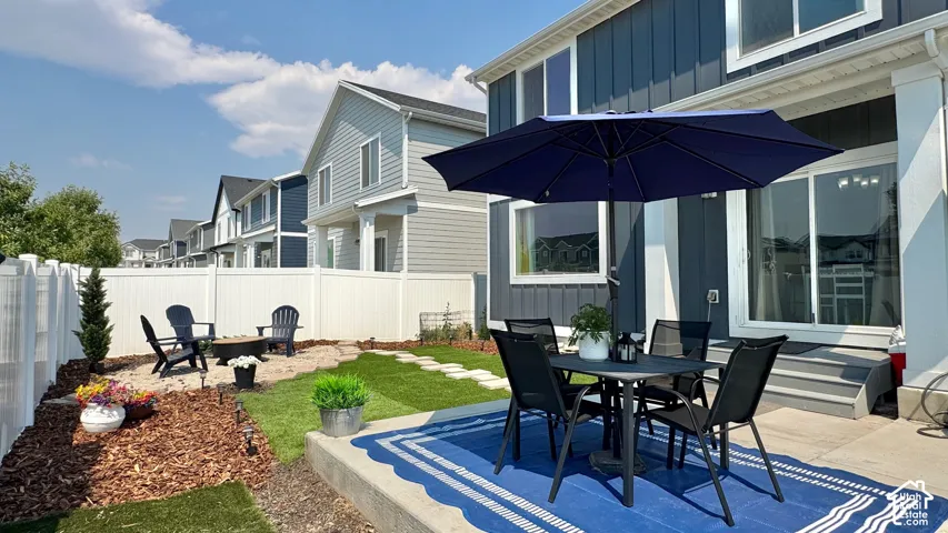 Backyard patio featuring concrete surfacing, a sliding glass door entry, and a dedicated fire pit area