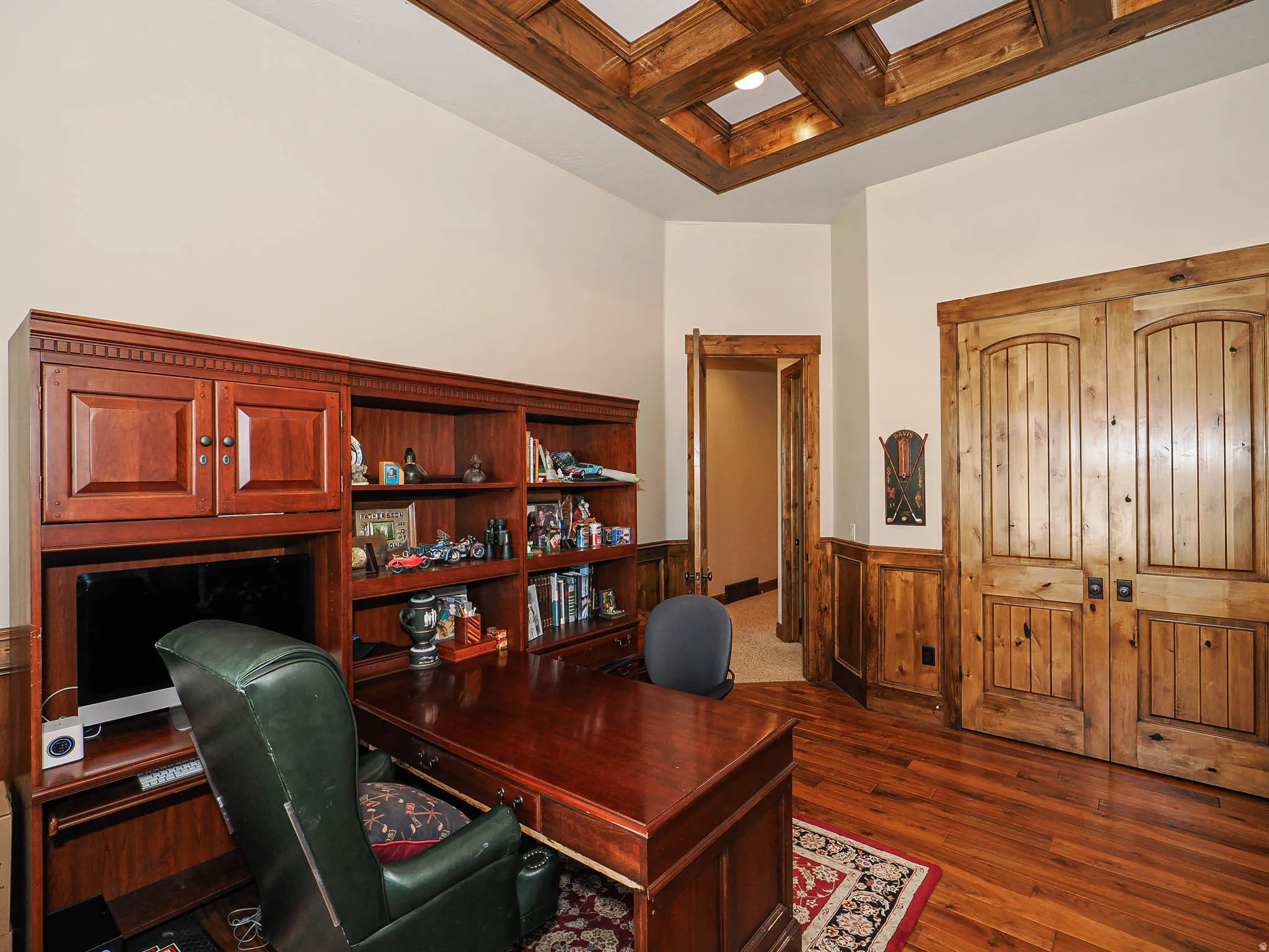 Room featuring a coffered wood ceiling, wood-finish flooring, and wainscoting