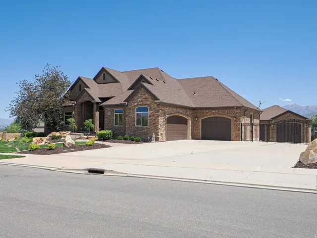 Stone and brick veneer exterior featuring multiple gables and a multi-car driveway