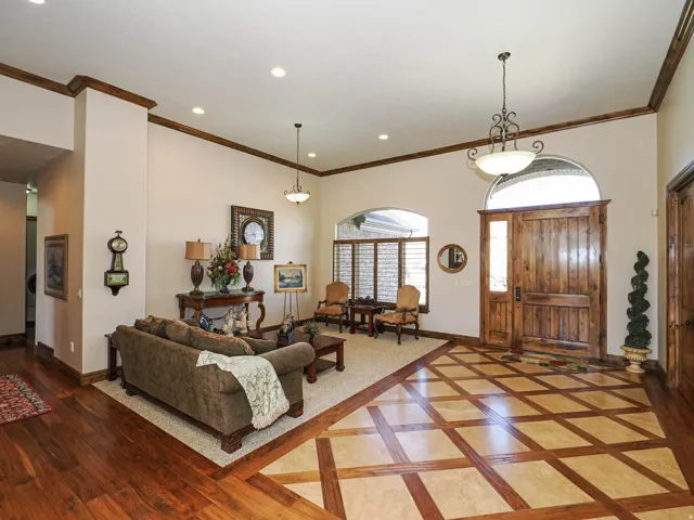 Expansive entry featuring a wood-finish door with an arched transom, patterned tile flooring with wood-finish accents, recessed lighting, and crown molding