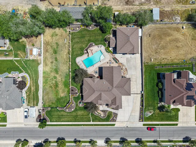 Expansive property featuring a large residence, detached garage, and a swimming pool with surrounding patio