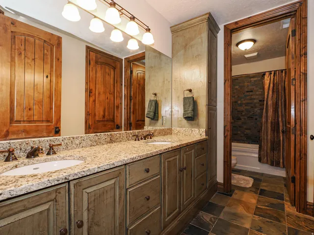 Dual vanity with light granite-look countertop and bronze-finish fixtures