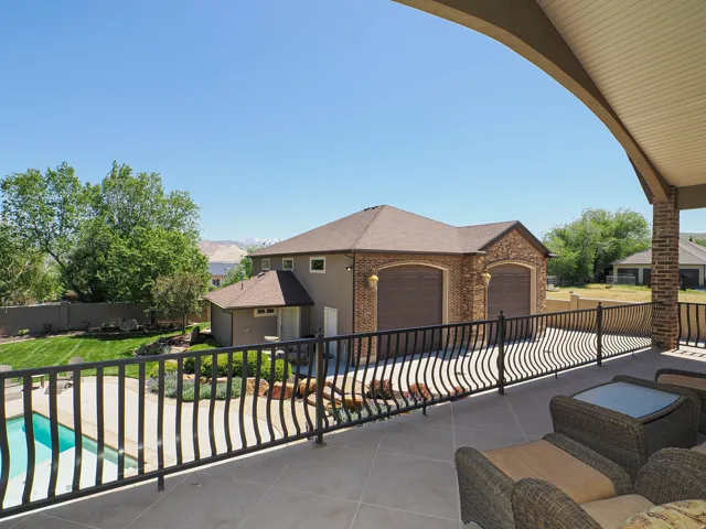 Expansive outdoor patio with tile flooring and decorative metal railing