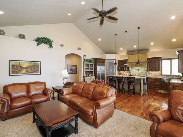 Open-concept living area featuring a vaulted ceiling with recessed lighting and a ceiling fan