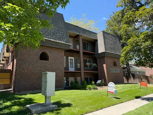 Brick facade building with mansard-style roofing and private balconies