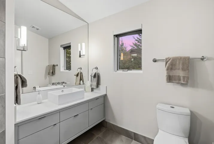 Half bathroom with vanity and dark tile patterned floors