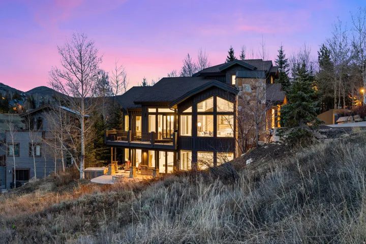 Back of house at dusk with a patio area and board and batten siding
