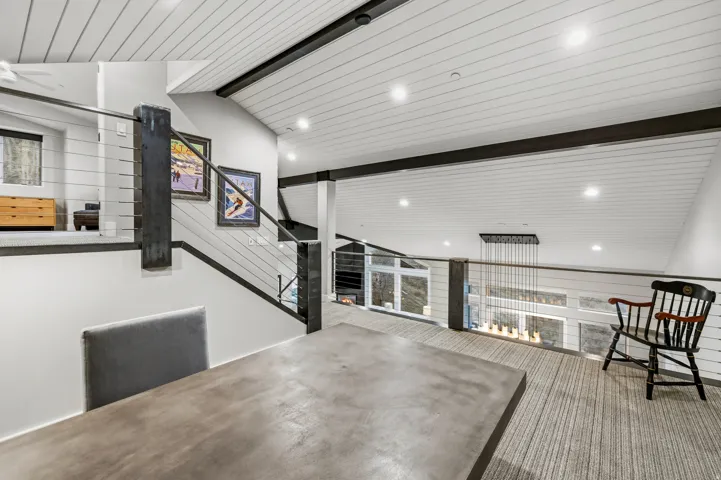 Unfurnished room featuring a warm lit fireplace, a wood ceiling with exposed beams, and recessed lighting