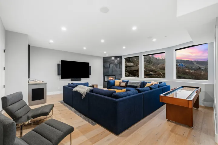 Living room featuring light wood-type flooring, recessed lighting, and a warm lit fireplace