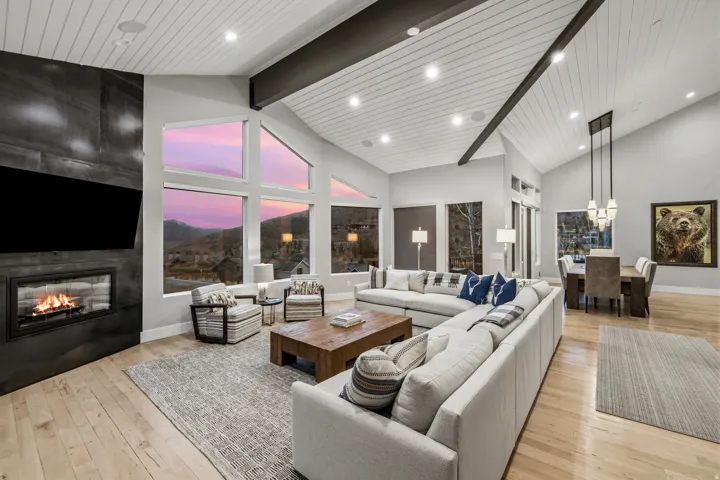 Living area featuring a large fireplace, a high wooden beamed ceiling, and light wood finished floors