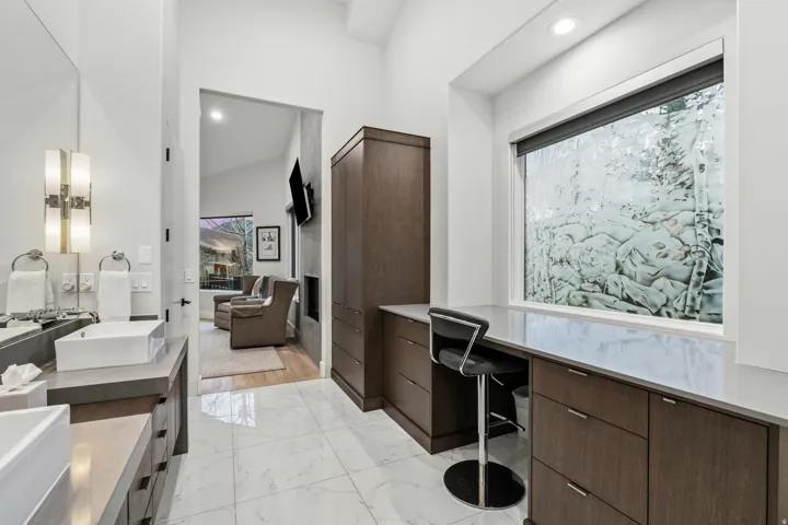 Full bathroom with double vanity, light marble finish floors, and recessed lighting