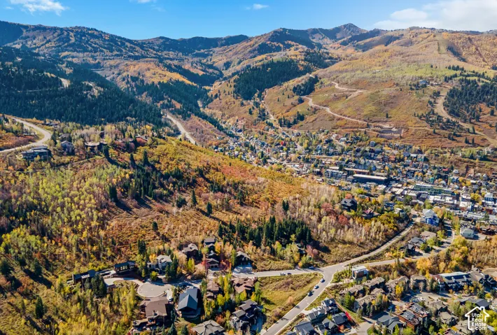 Aerial perspective of mountainous terrain featuring dense forestation, ridgelines, and expansive valleys