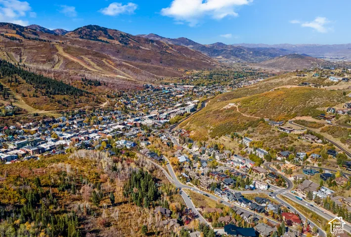 Aerial perspective featuring expansive mountain terrain, dense native vegetation, and a winding infrastructure grid