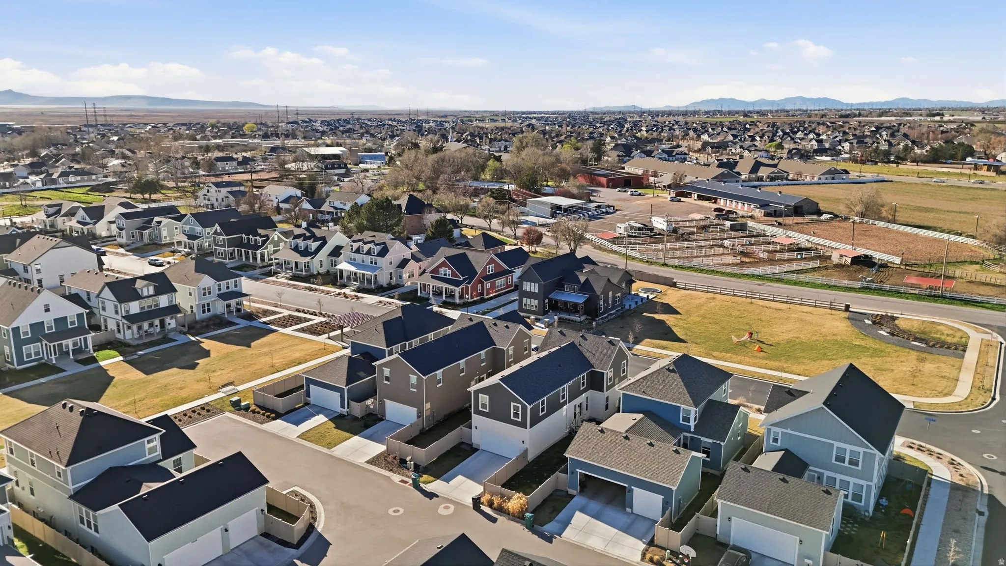 Aerial overview of property's location with nearby suburban area and a mountainous background