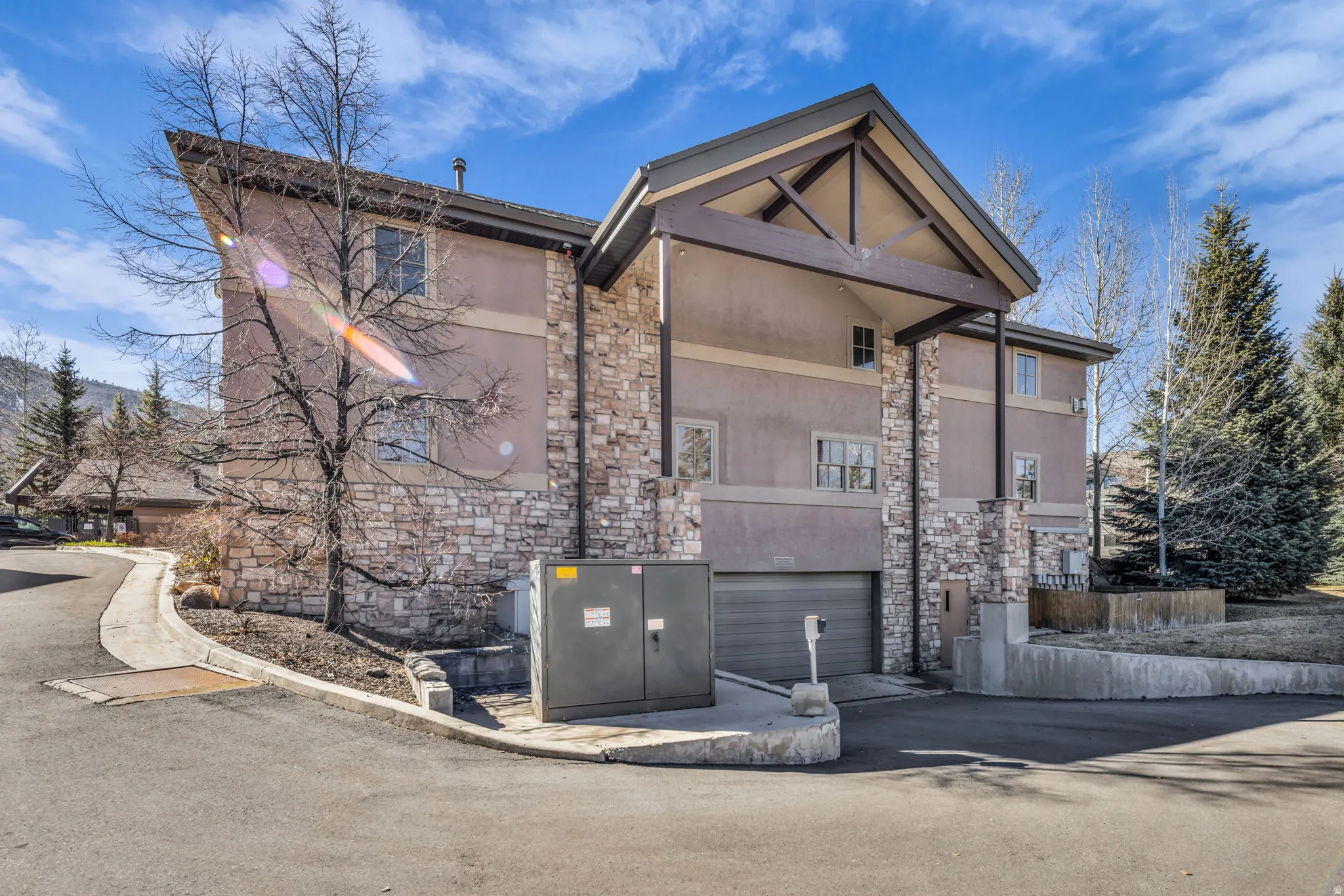 View of front facade featuring stone siding, stucco siding, and a garage