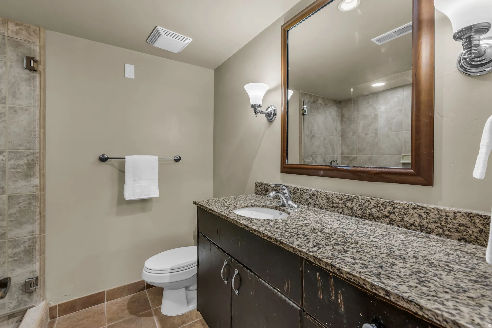Bathroom featuring vanity, a shower stall, light tile patterned floors, and recessed lighting