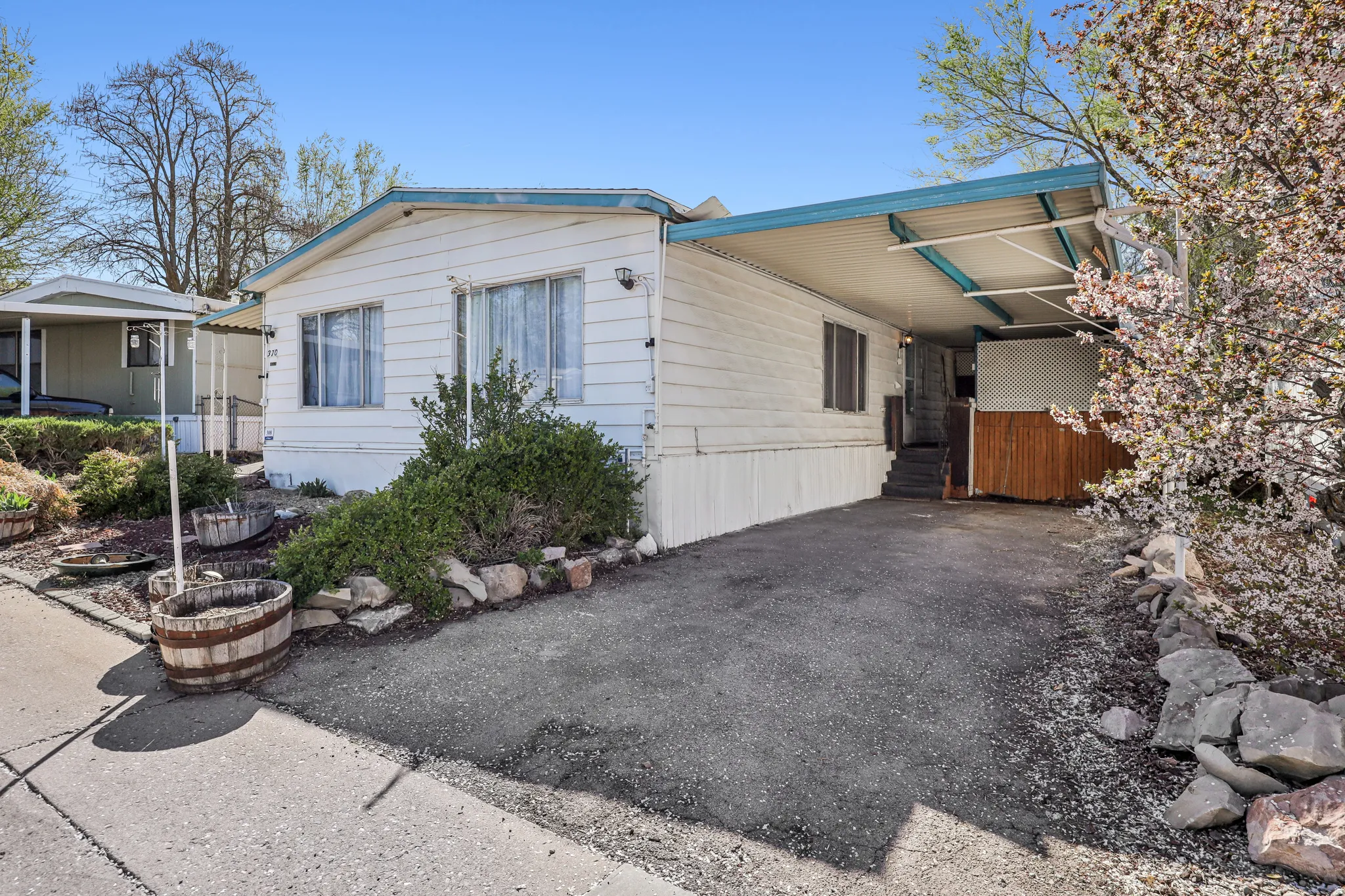 View of front of property featuring a carport and asphalt driveway