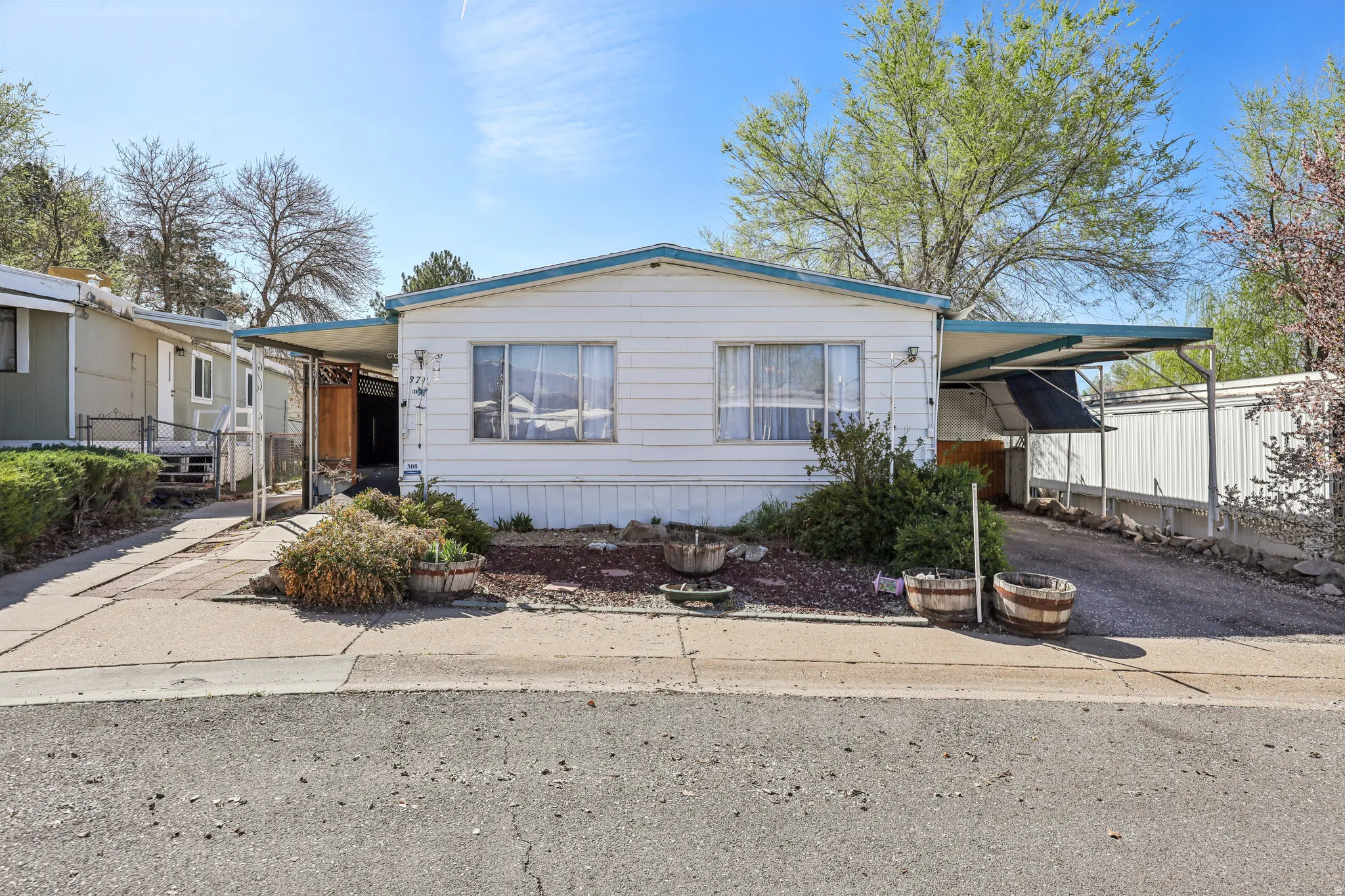 Manufactured / mobile home featuring an attached carport and driveway