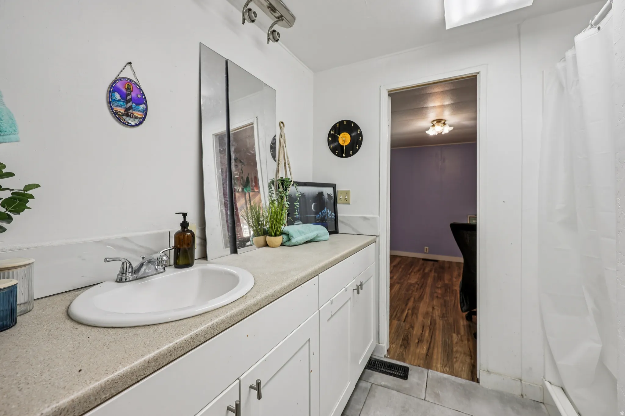 Full bathroom featuring vanity, a shower with curtain, and light tile patterned floors
