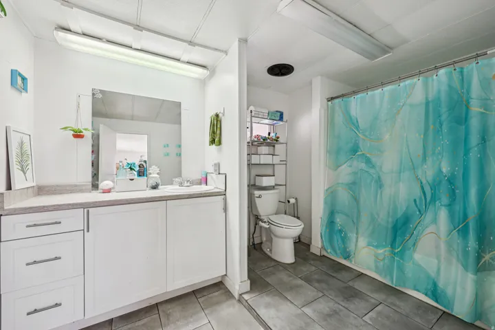 Bathroom featuring vanity, light tile patterned flooring, and shower / bathtub combination with curtain