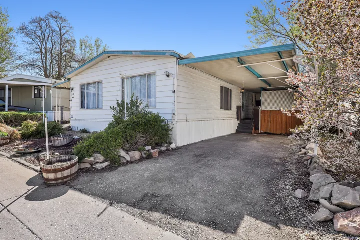 View of front of property featuring a carport and asphalt driveway