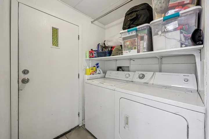 Laundry area with washer and clothes dryer and concrete floors