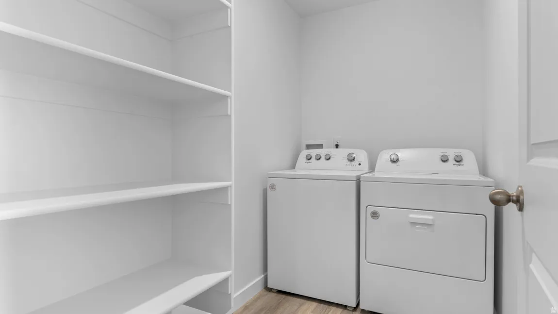 Laundry room featuring light wood finished floors and washer and dryer