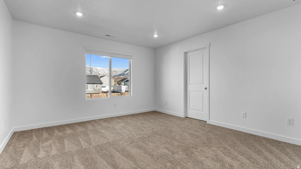 Carpeted spare room with baseboards and recessed lighting