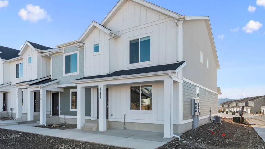 Modern farmhouse style home with covered porch, a residential view, and board and batten siding