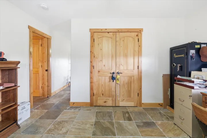 Home office featuring stone tile floors and baseboards