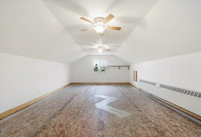 Additional living space featuring a ceiling fan and baseboards