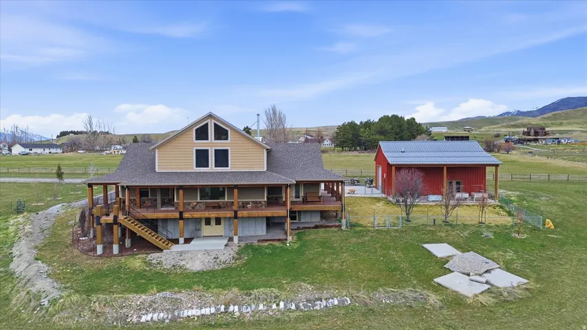 Back of property featuring an outbuilding, a yard, a deck with mountain view, and a view of rural / pastoral area