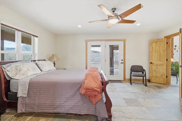 Bedroom with light stone finish floors, ceiling fan, access to exterior, and recessed lighting